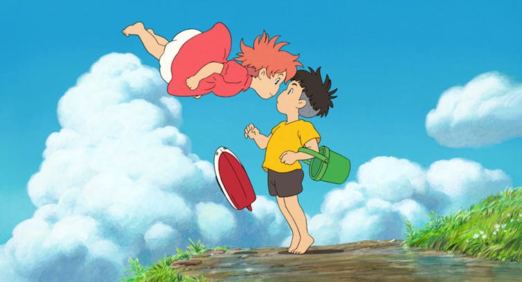 A child with red hair floats in the air, her face pressed to that of a boy stood on the ground.