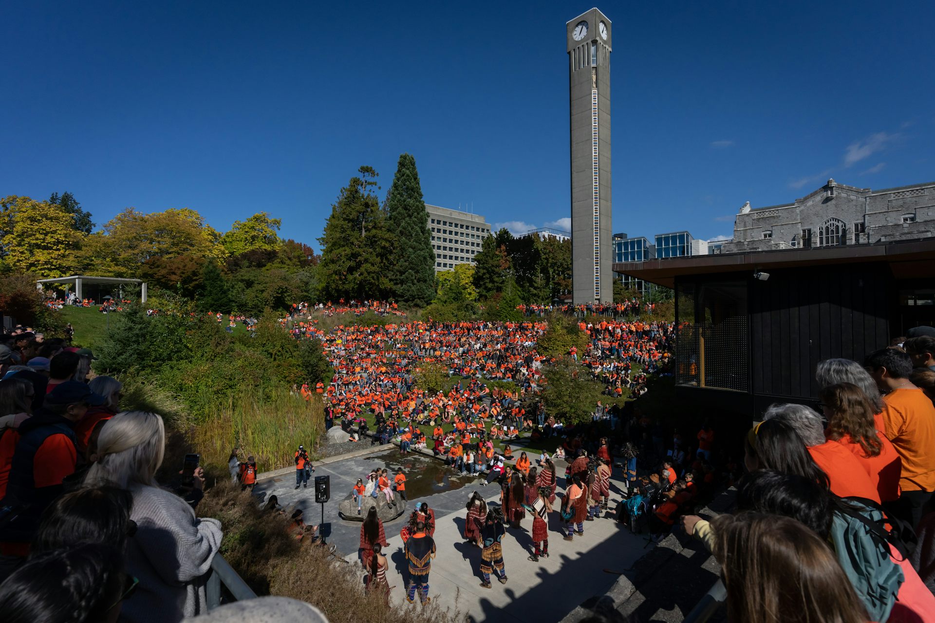 People in orange shirts outdoors.