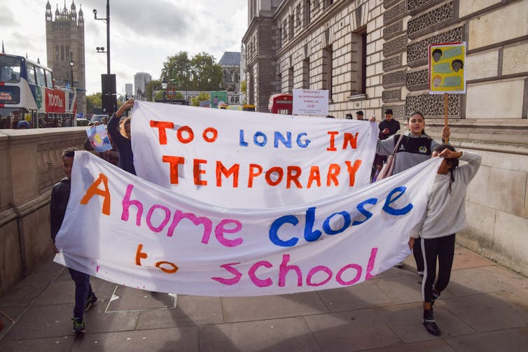 People hold up banners at a protest.