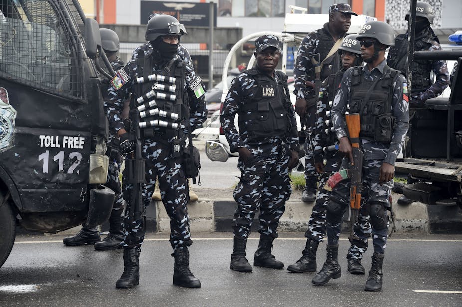 Men in helmets, bulletproof vests camouflage uniform, carrying weapons.