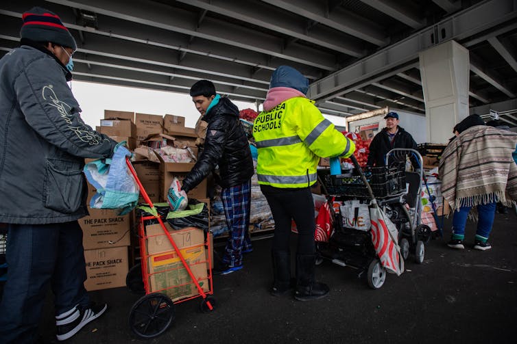 People bundled up for cold weather receive donated food.