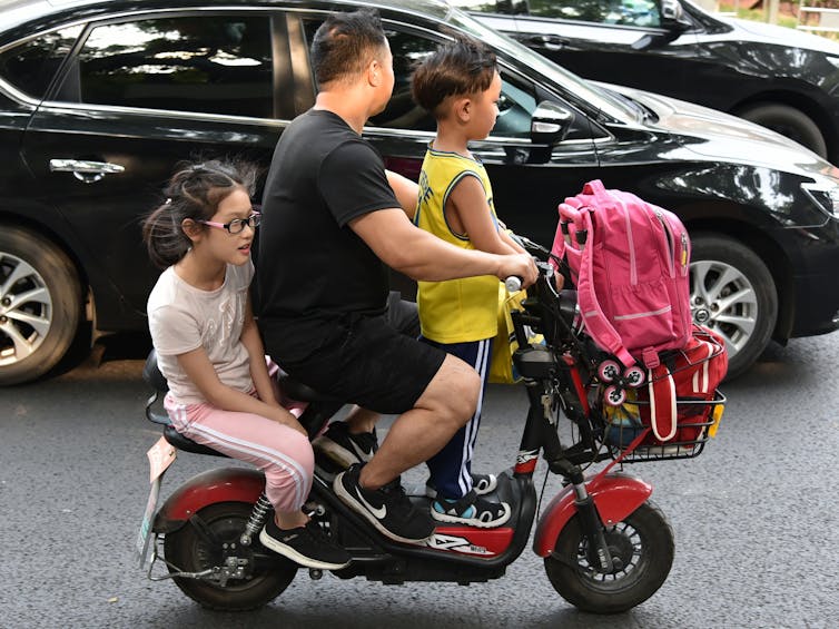 familia en ciclomotor eléctrico en Pekín, China