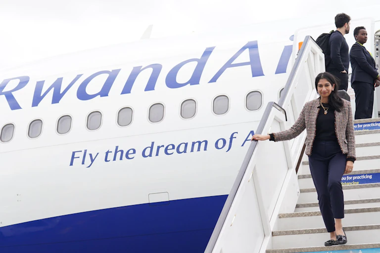 Former home secretary Suella Braverman walking down the stairs of a RwandaAir plane
