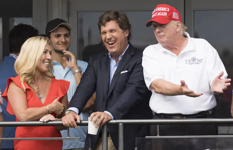 Donald Trump with former Fox host Tucker Carlson and Republican congresswoman Majorie Taylor Greene.