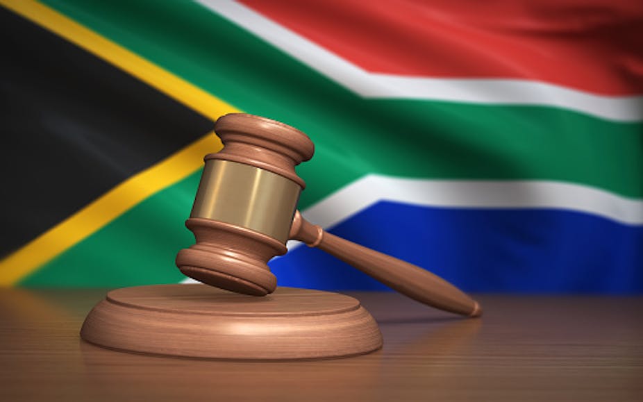 A judge's gavel in front of the South African flag.