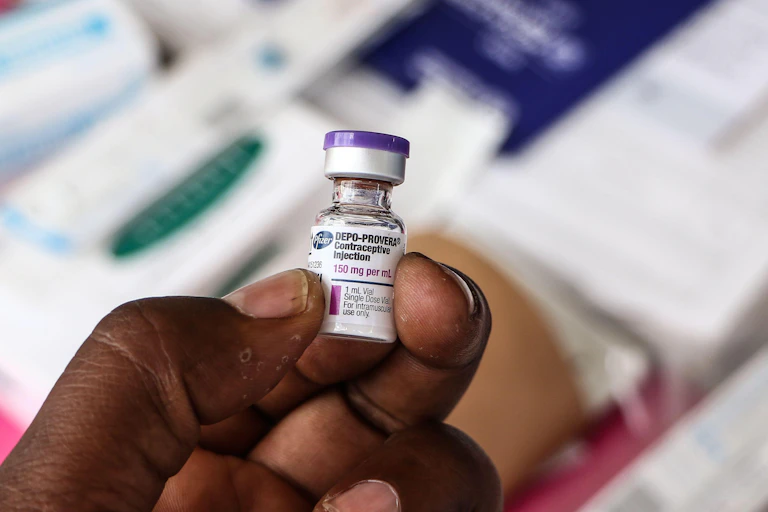 Hand holding a phial of Depo-Provera