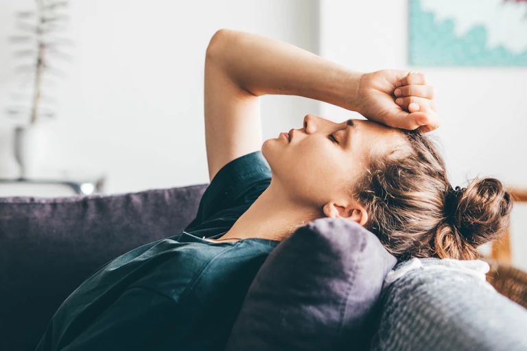 Woman puts puts hand to forehead, exhausted