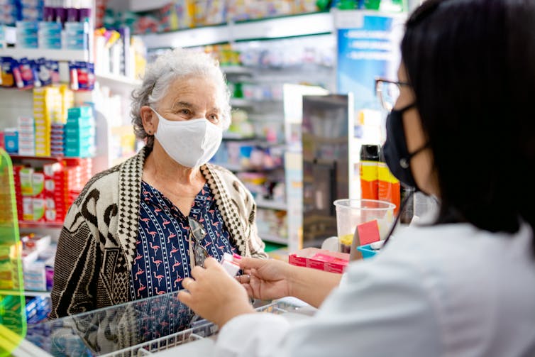 Pharmacist gives antivirals to older patient
