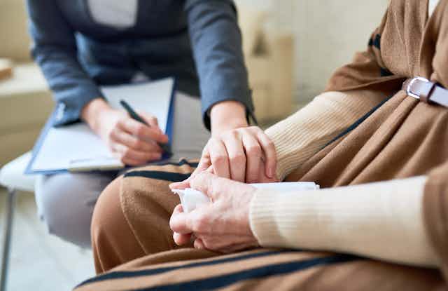 hands of a therapist reaching over to comfort a client