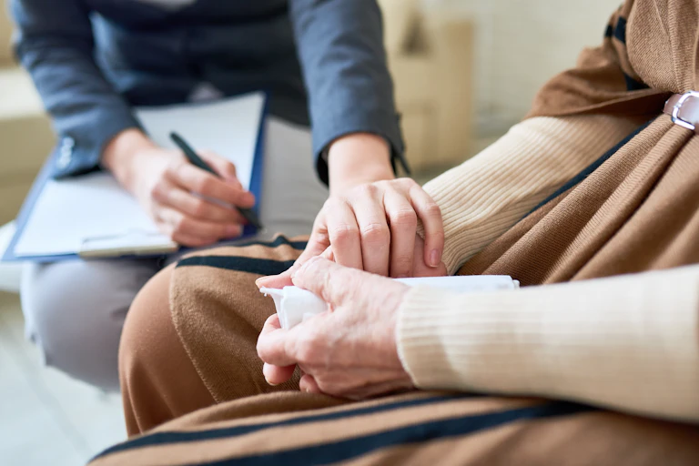 hands of a therapist reaching over to comfort a client