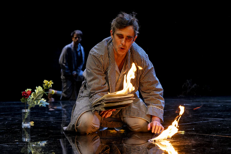 A man holds a burning book