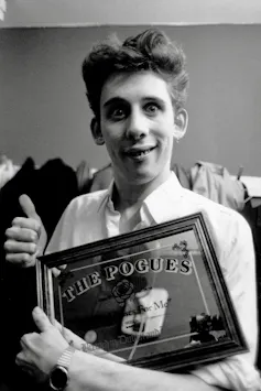 MacGowan holds a mirrored plaque