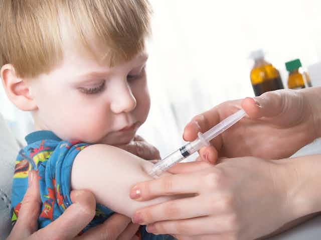 A child receive a vaccine from their doctor.