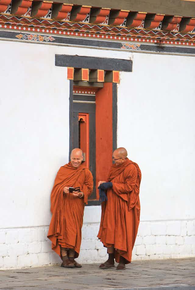 Buddhist monks checking their mobile phones