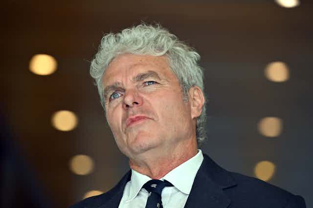 A grey-haired man photographed from below