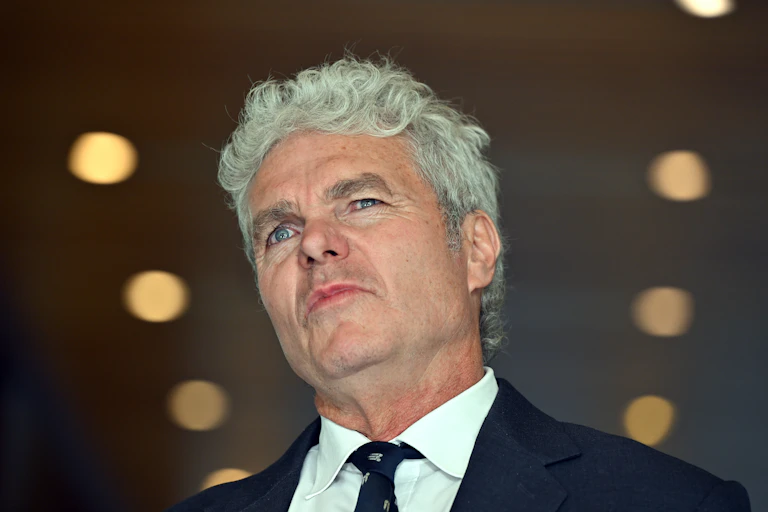 A grey-haired man photographed from below