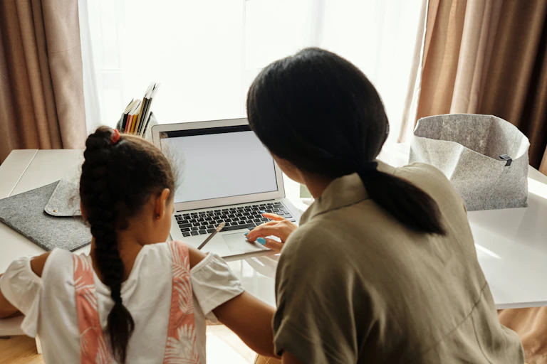 A mother and child work at a desk.