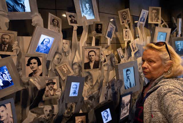A woman looks at photos of people who died in the Holocaust
