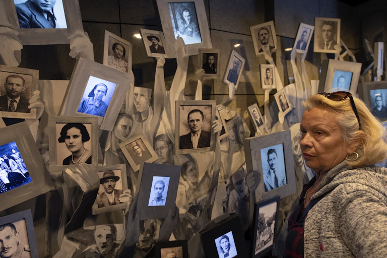 A woman looks at photos of people who died in the Holocaust