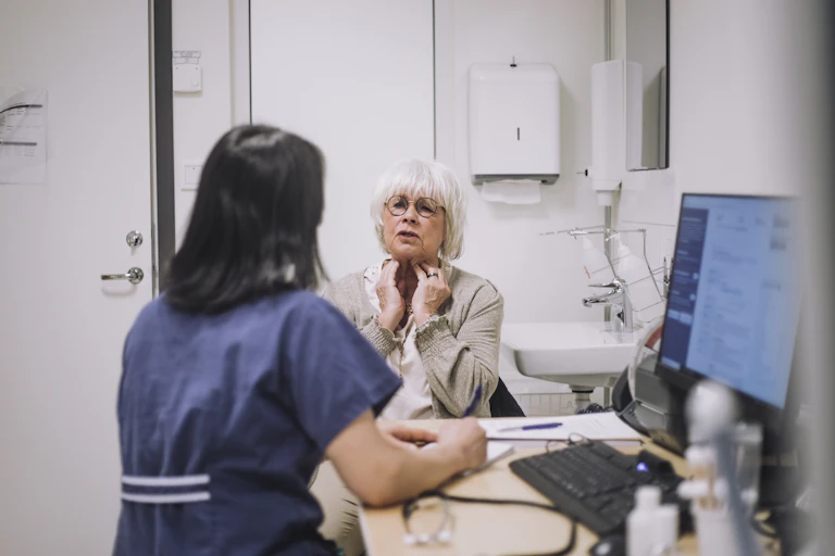 Woman describes symptoms to her GP