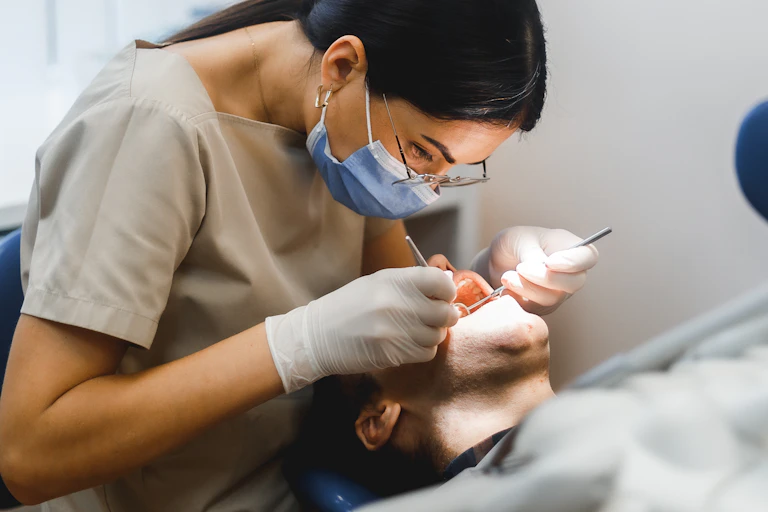 Dentist examines person's mouth
