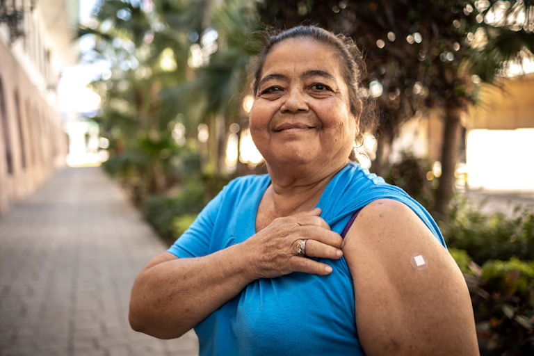 Woman shows arm where she has been vaccinated