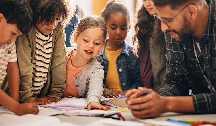 Teacher with group of children at table