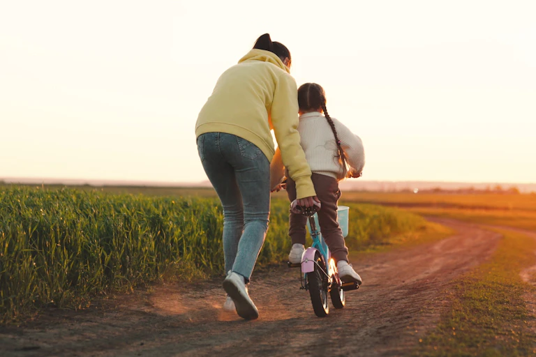 Mother pushing child on bike