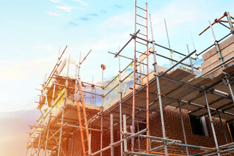 Construction underway on a house with scaffolding.
