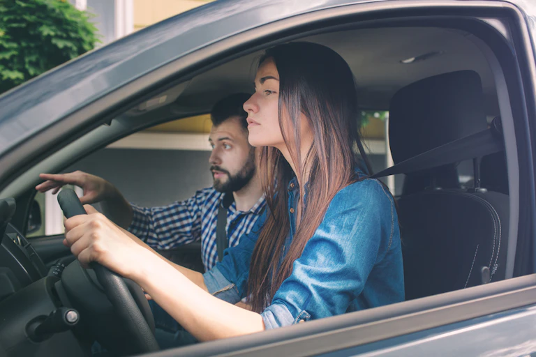 Jeune femme sérieuse conduisant une voiture ne se sentant pas expérimentée