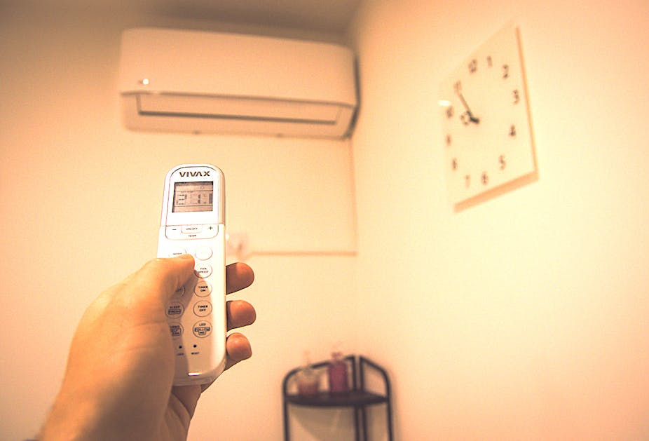 Une personne règle la climatisation à son domicile.