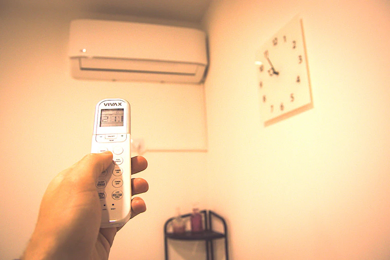 Une personne règle la climatisation à son domicile.