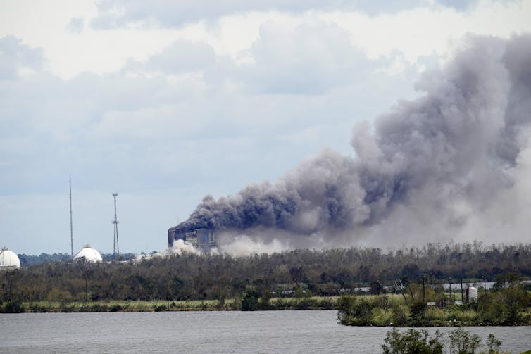 A huge grey plume billows from an industrial facility.