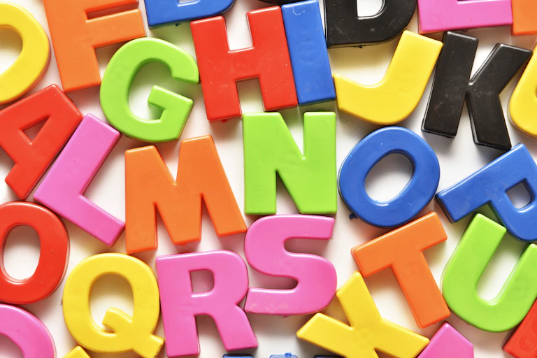 A colorful illustration of the letters of the alphabet, disordered and jammed together atop a white background.