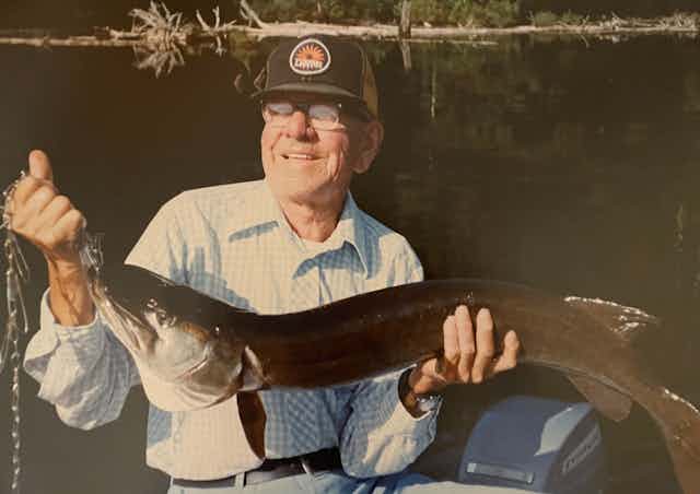 A man seen holding a fish.
