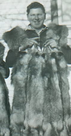 A man seen holding animal pelts.