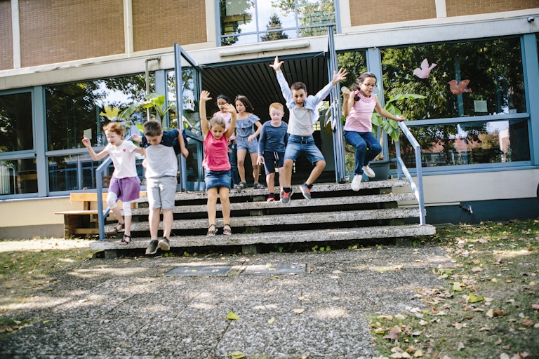 young children jumping off steps at a school