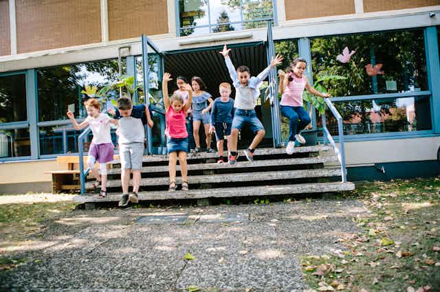 young children jumping off steps at a school