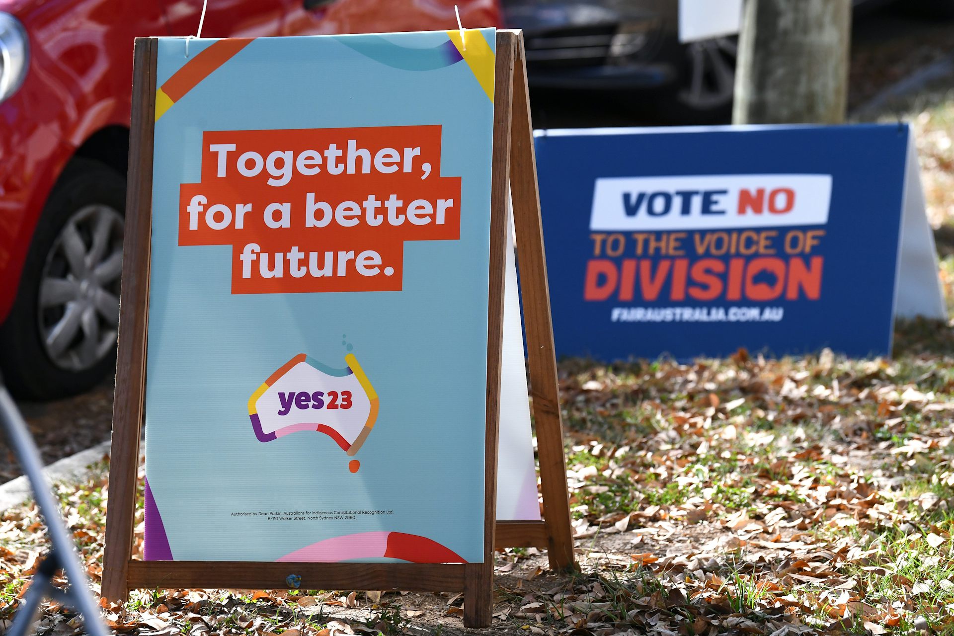 Two political billboards outside a polling booth.