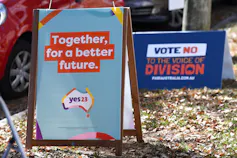 Two political billboards outside a polling booth.