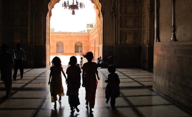 Children walk together in a building in Pakistan