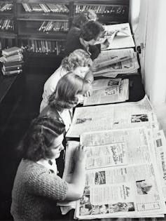 1960s photo, girls read newspapers.