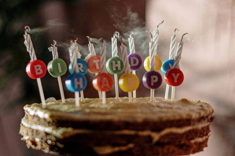 A birthday cake with candles that spell out Happy Birthday.
