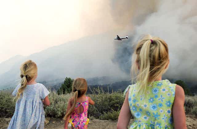 Three girls facing bushfire smoke.