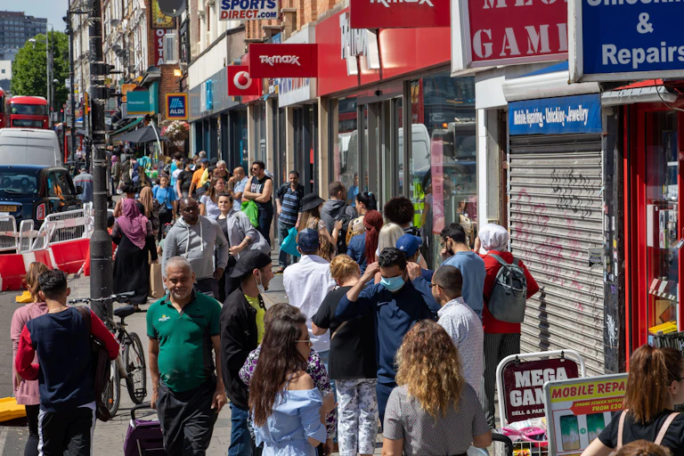 Crowds on the pavement of a city high street.