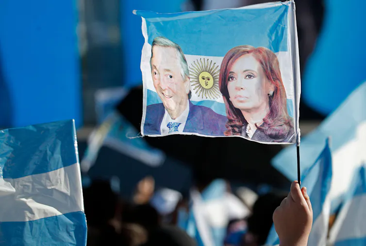 Peronist supporters with a flag of former president Cristina Fernández de Kirchner and her late husband Nestor.