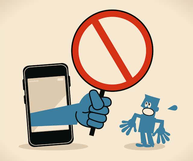 A cartoon shows a hand extending from a smartphone, holding a red circle with a line across it, and a cartoon person looking surprised.