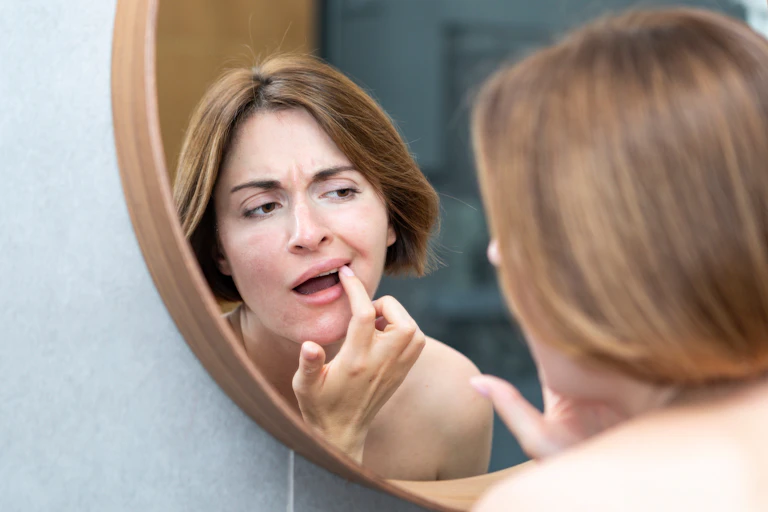 Woman checking her mouth in the mirror
