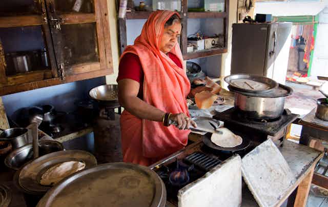 An Indian woman cooks a chapati