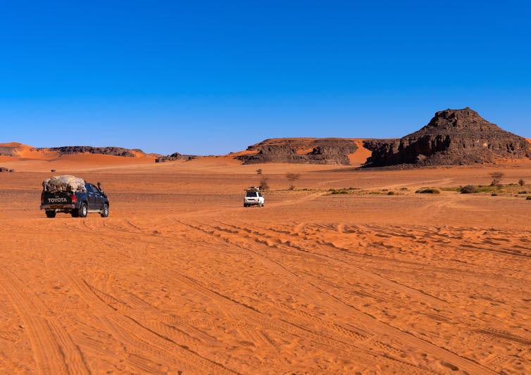 Trucks driving through the desert.